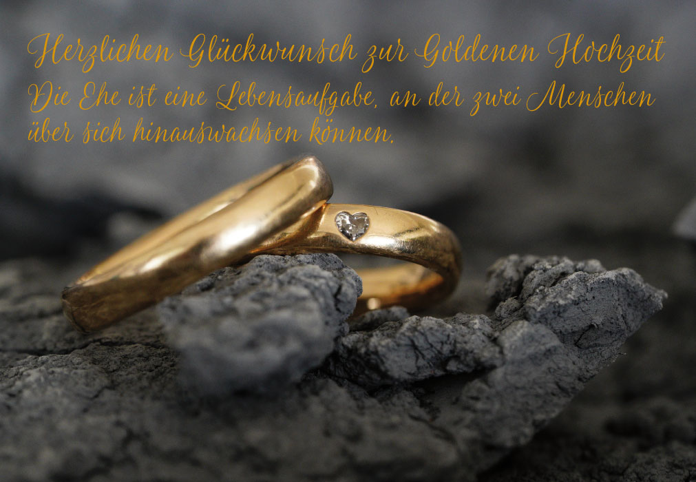 Goldhochzeit - goldene Ringe auf schwarzer Erde