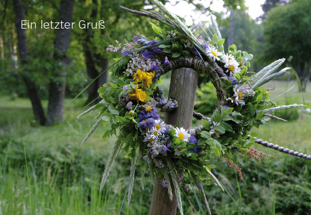 Trauer - Blumenkranz an Zaun